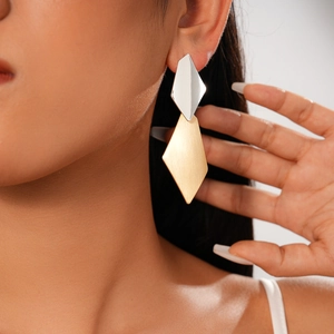 Detail view of irregular geometric earrings with silver and gold brushed metal finish