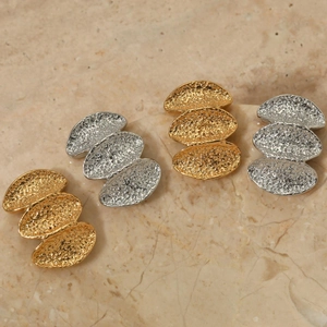 Detail of 316 stainless steel earrings with gold and silver hammered lava texture finish