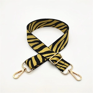 Detail of zebra pattern bag strap with adjustable buckle and gold metal lobster hooks