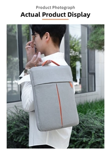 Slim grey laptop sleeve with orange accents shown as a stylish shoulder bag on male model