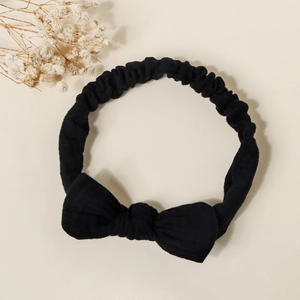 Detailed close-up of a black ribbed cotton headband with a large bow for babies
