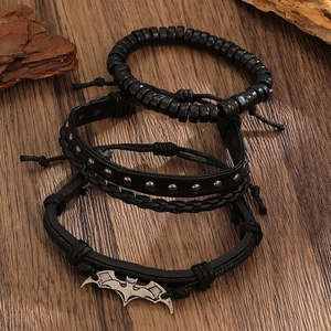Detalle del conjunto de tres pulseras negras con colgante de murciélago en madera