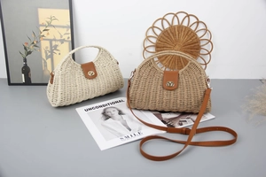 Detail of straw woven crossbody bags with leather flap and round metallic buckles