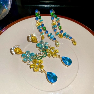 Detailed macro view of colorful rhinestone flower and double-row tassel drop earrings