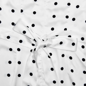 Detail of white polka dot fabric with an elegant bow tie on a slim-fit summer dress