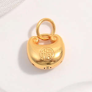 Close-up of a gold Fu character lock pendant charm with a polished metallic finish