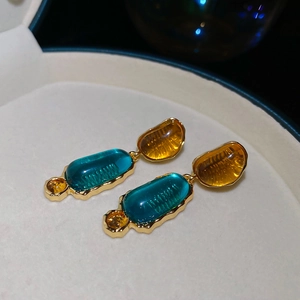 Details von Vintage-Ohrhängern aus Harz mit Goldrahmen in Blau- und Bernsteintönen