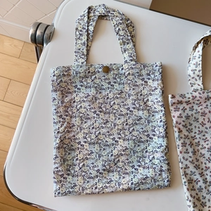 Close-up of floral cotton tote bag featuring vintage pattern and bronze metal button closure
