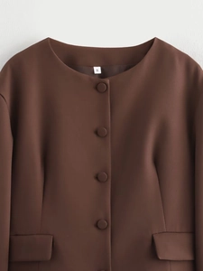 Close-up of chocolate brown round neck blazer with matching buttons and flap pockets