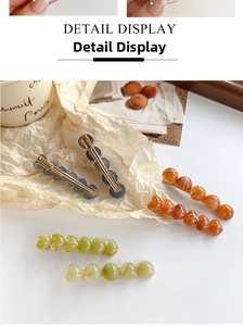 Detail view of colorful heart-shaped resin bead hair clips with gold duckbill clips