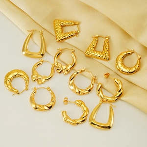 Collection of golden hoop earrings in various designs on elegant silk fabric