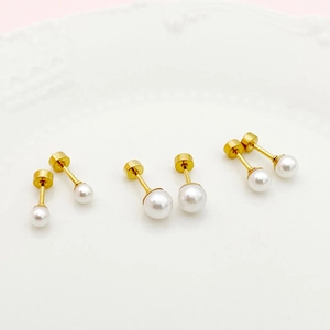 Three pairs of sweet minimalist pearl stud earrings with gold plating on a ceramic plate