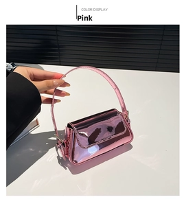 Close-up of a pink metallic baguette bag with mirror finish and slim handle strap