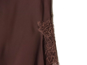 Detailed close-up of dark brown satin skirt featuring delicate eyelash lace trim edges