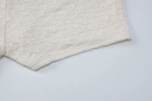 Détail macro du tissu en dentelle blanc cassé respirant avec texture mesh et coutures