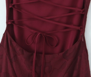 Detail eines weinroten rückenfreien Kleides mit Schnürung und Jacquard-Struktur