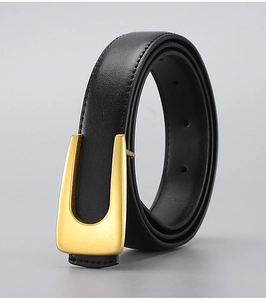 Detail of premium black leather belt with a matte gold U-shaped buckle and fine stitching