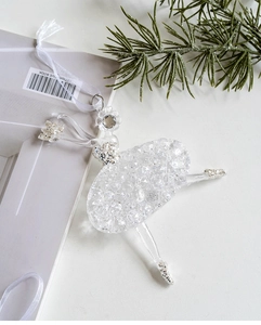 Elegant transparent acrylic ballerina ornament with silver glitter on white tabletop