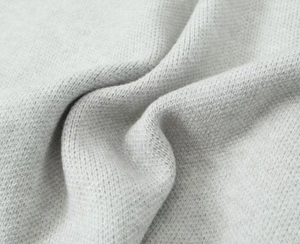Close-up of high-density light grey chunky knit texture on a soft lapel cardigan