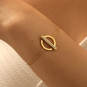 Gold plated stainless steel bracelet with geometric circle and paved diamond bar on wrist