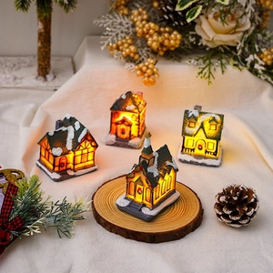 Lighted Christmas resin village houses with snow roofs and warm LED glow for desktop decor
