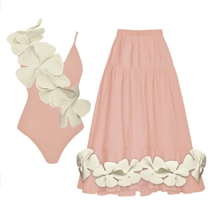 Detailed view of pink one-piece swimsuit and tiered skirt with large 3D floral accents