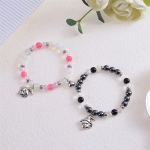Magnetic heart couple bracelets with wizard hat pendants and crystal beads on white background