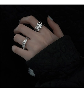 Close-up of liquid silver style irregular lava texture rings worn on hand