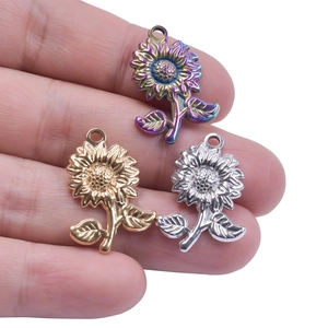 Macro detail of sunflower pendants in rainbow, gold, and silver finishes on a palm