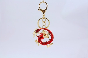 Close-up of red and gold dragon keychain featuring intricate enamel texture and lobster clasp