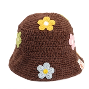 Detail of handmade crochet fisherman hat with colorful floral patterns and brand label