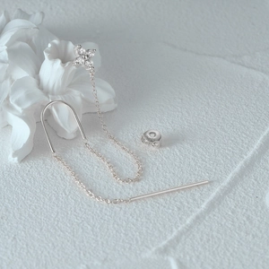 Macro detail of S925 silver four-leaf clover tassel earrings with cubic zirconia