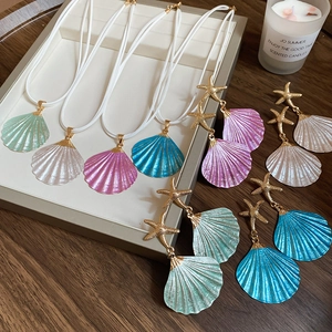 Flat lay of colorful seashell jewelry set including four necklaces and starfish earrings