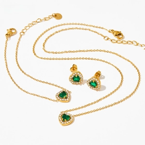 Détails de parure de bijoux cœur dorée avec zircones vert émeraude et petits cristaux blancs