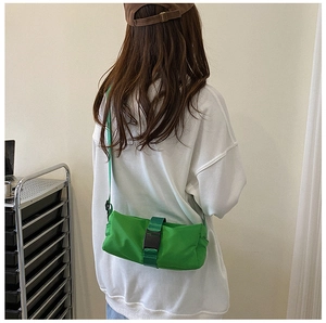 Detail shot of bright green nylon crossbody bag showing the buckle and waist position