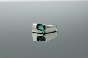 Macro shot of silver ring featuring an emerald-cut green zircon stone in a bezel setting