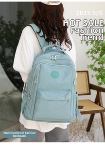 Back view of light blue water-resistant nylon backpack with multi-compartments for travel
