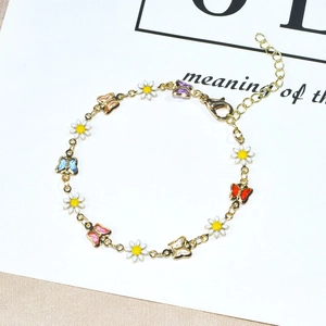 Detail of gold bracelet with colorful enamel butterfly and daisy charms with lobster clasp