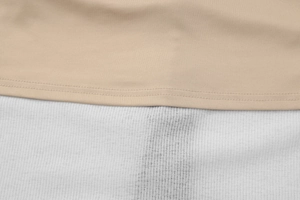 Détail macro du tissu lisse abricot cousu sur une texture côtelée blanche avec coutures fines
