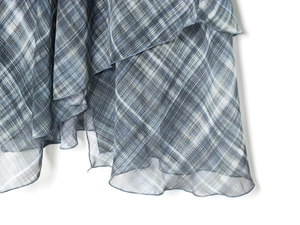 Détail de tissu en mesh transparent à carreaux bleu-gris avec texture à volants