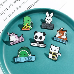Set of 7 colorful cartoon animal enamel pins including rabbit and panda on a green tray
