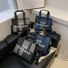 Detail of canvas tote bags with adjustable straps and The Tote Bag lettering