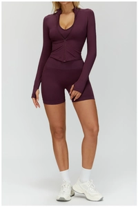 Détail d'une veste de yoga violet foncé avec passe-pouces et short de sport taille haute