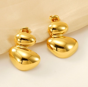 Detail of gold irregular stacked pebble earrings with a polished mirror finish