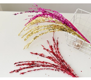 Sparkly sequin decorative branches in magenta gold and red for festive tree arrangements