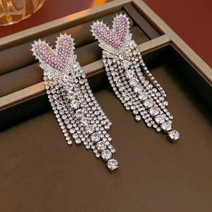 Detail of pink crystal heart earrings with sparkling silver fringe tassels on jewelry tray