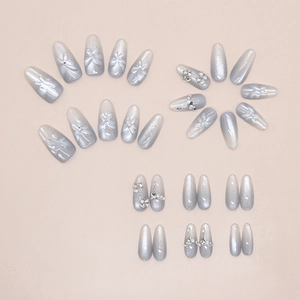 Dettaglio di unghie finte cat-eye argento con rilievi floreali 3D e strass scintillanti