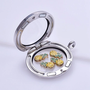 Detail view of a silver magnetic locket with small yellow pineapple floating charms inside