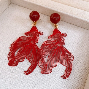Hollow goldfish drop earrings with red beads in a retro jewelry box display