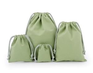 Detail view of four eco-friendly green cotton drawstring bags in various sizes